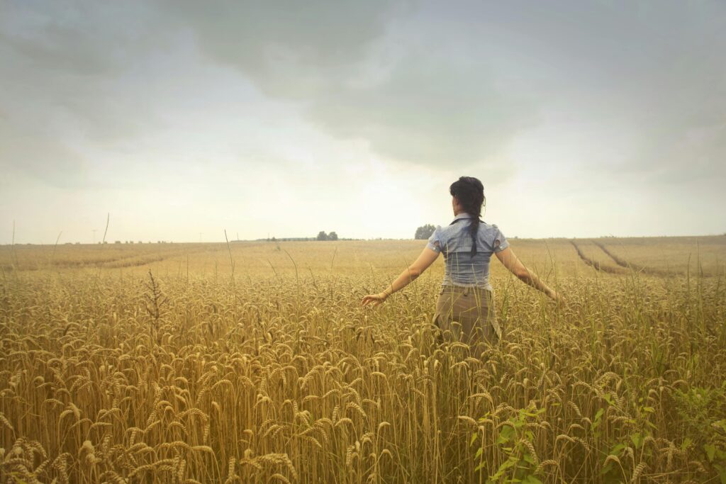 Woman Standing on Rice Field during Cloudy Day